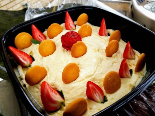 Freshella Catering banana mousse garnished with sliced strawberries and vanilla wafers